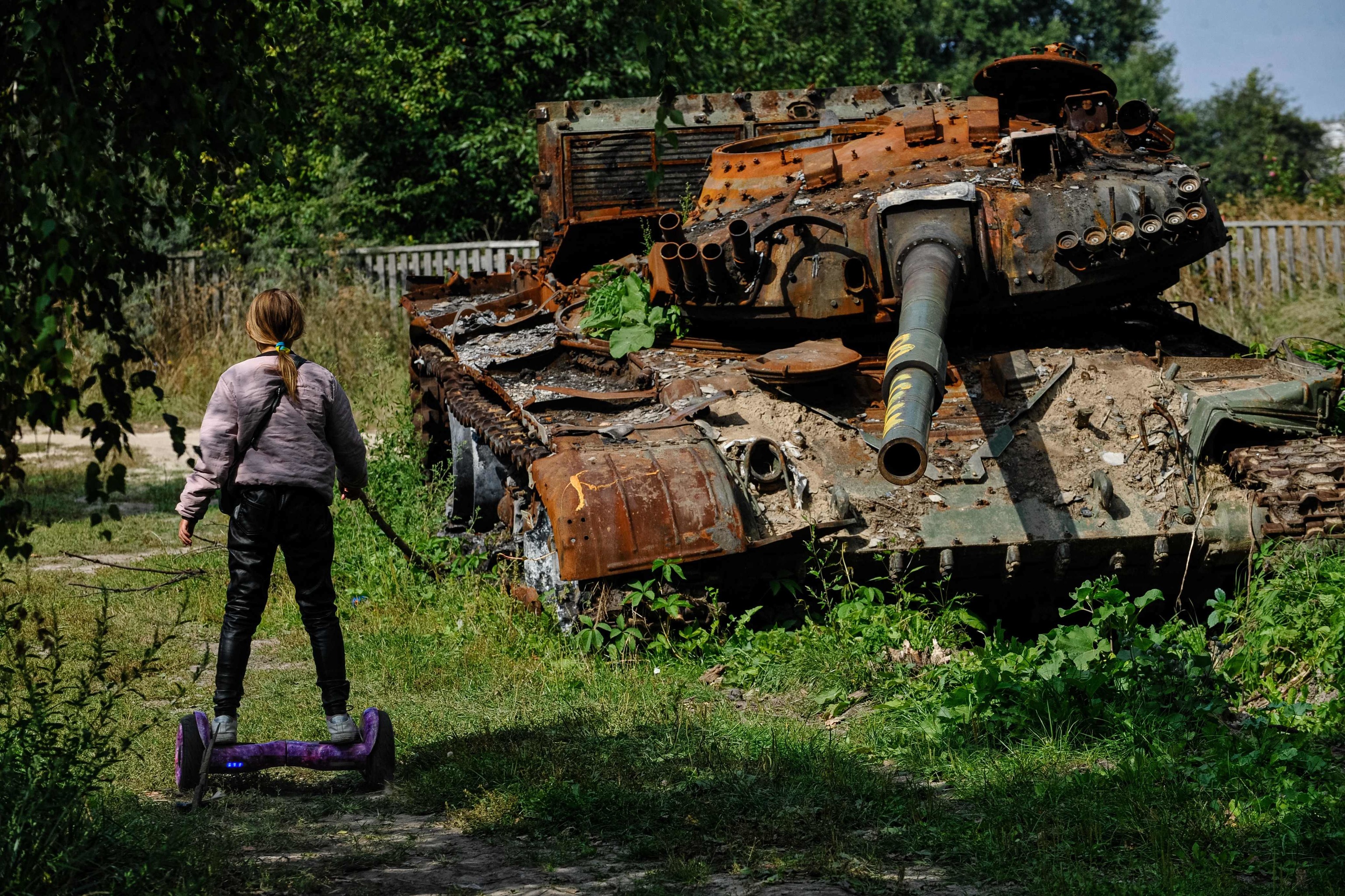 Un adolescente contempla un tanque de Rusia destruido en Ucrania