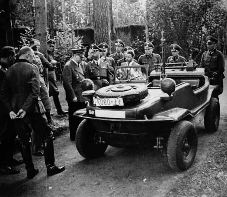 Ferry Porsche, de traje, junto a Hitler mientras este inspecciona el 'coche nadador