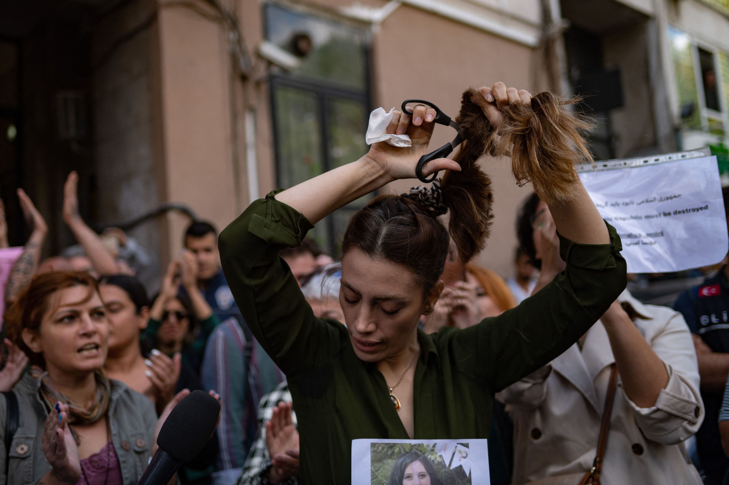 Una mujer se corta el pelo frente al consulado iran