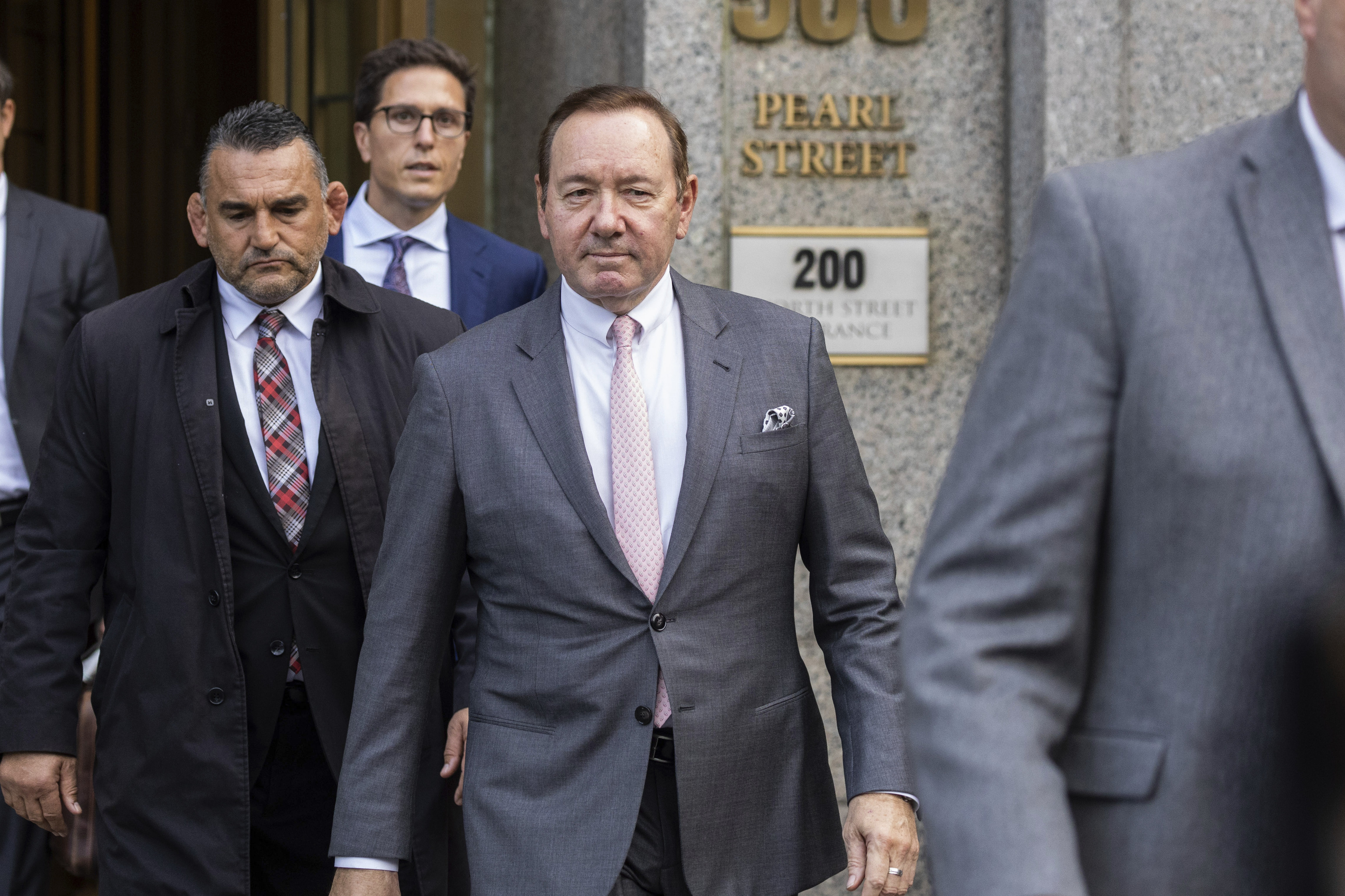 El actor Kevin Spacey, en el centro, sale del tribunal, el lunes 17 de octubre de 2022, en Nueva York. Spacey declar