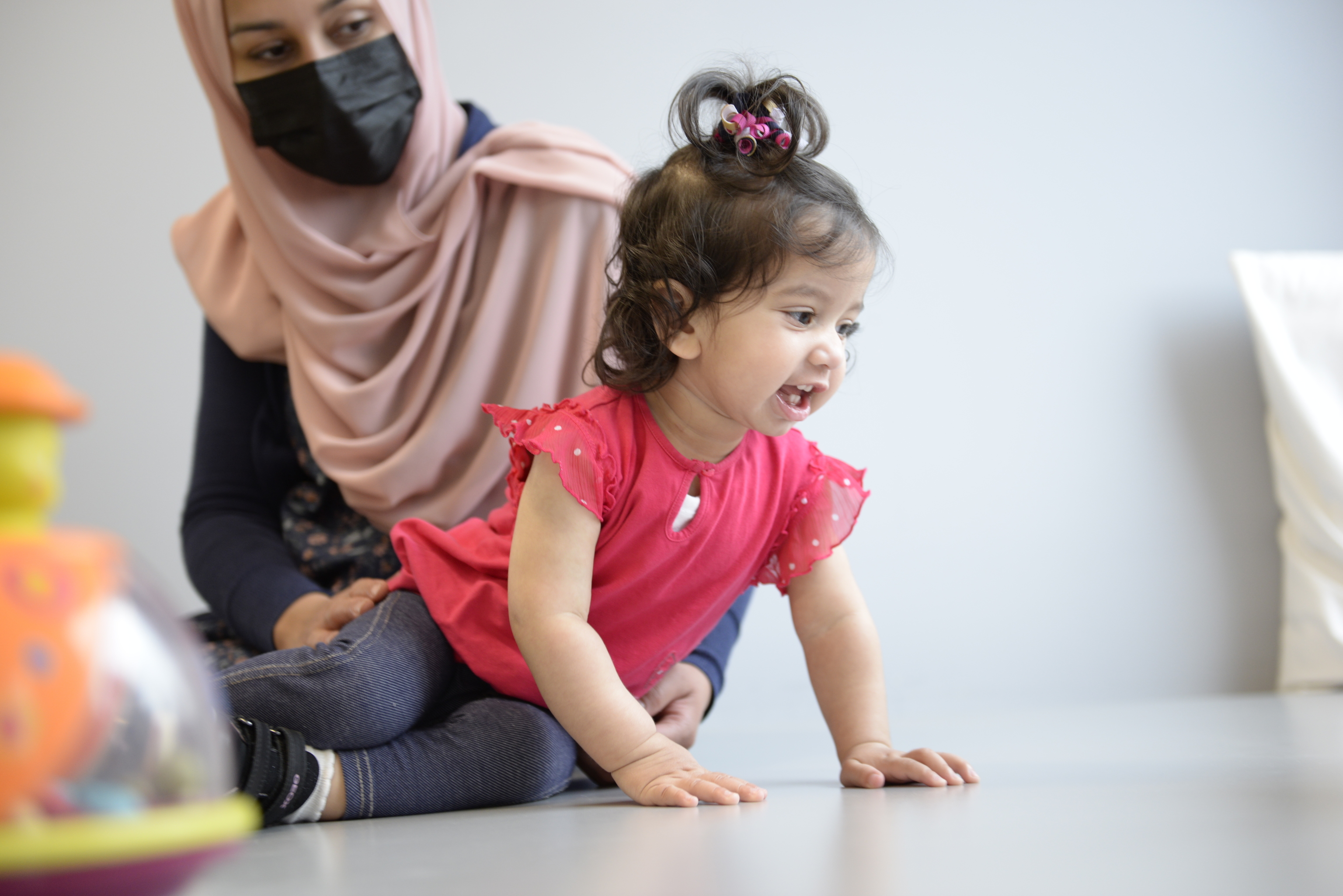 En esta foto proporcionada por el Hospital Infantil Eastern de Ontario, Ayla Bashir se sienta con su madre, Sobia Qureshi, durante una evaluación de fisioterapia.