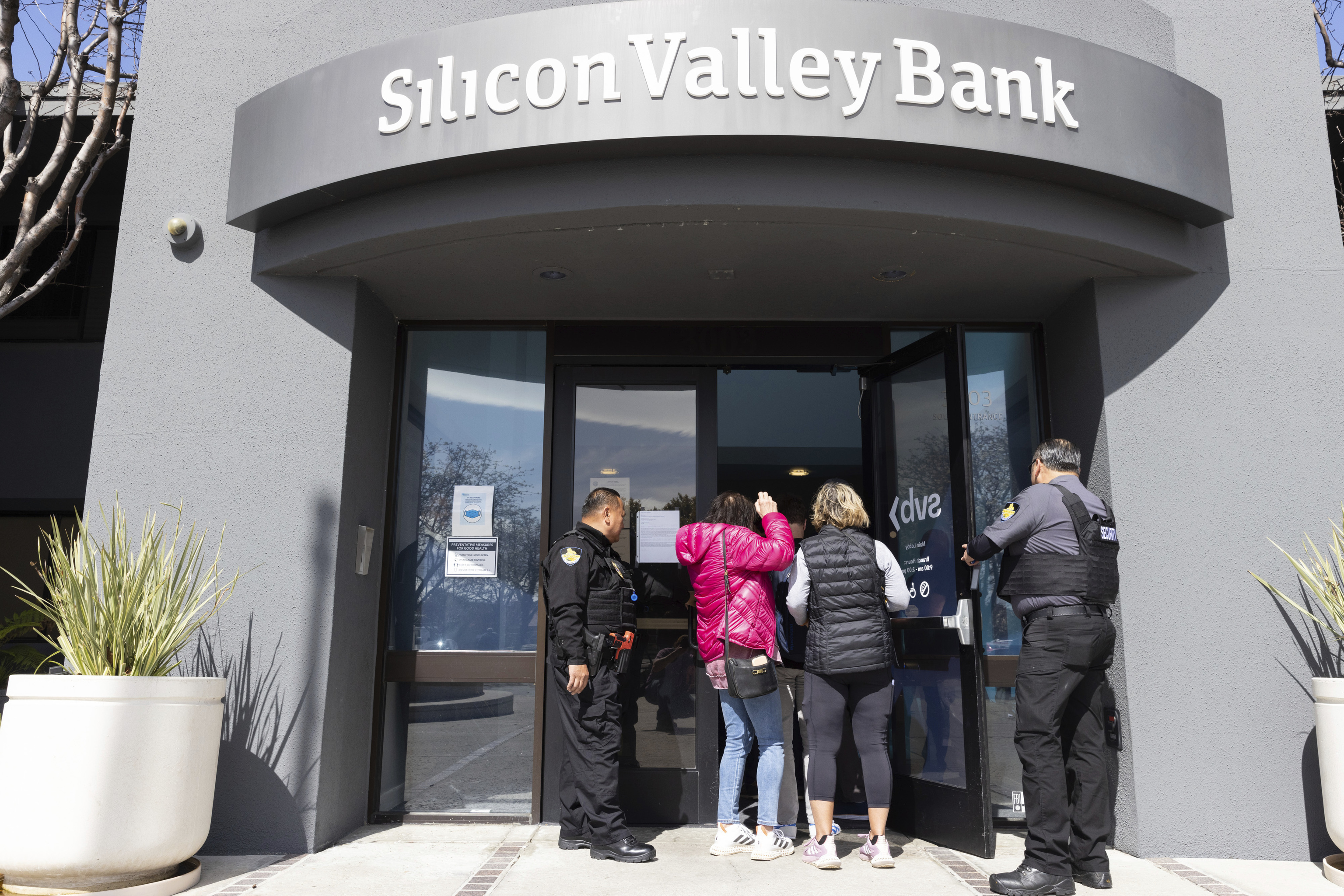 Guardias de seguridad permiten a personas ingresar en la sede del SVB.