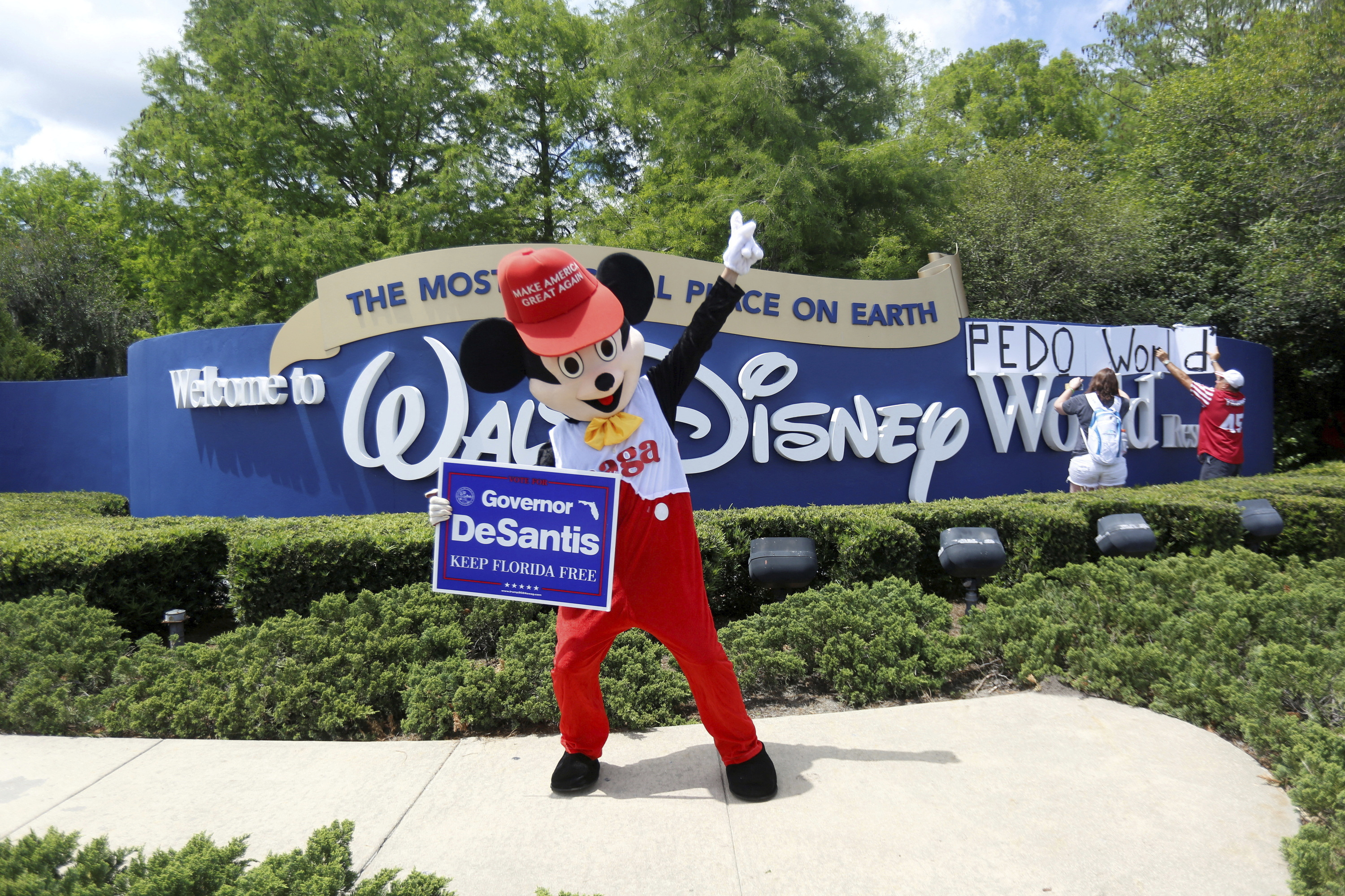 'Mickey Mouse' sostiene un cartel de DeSantis en Orlando, Florida.