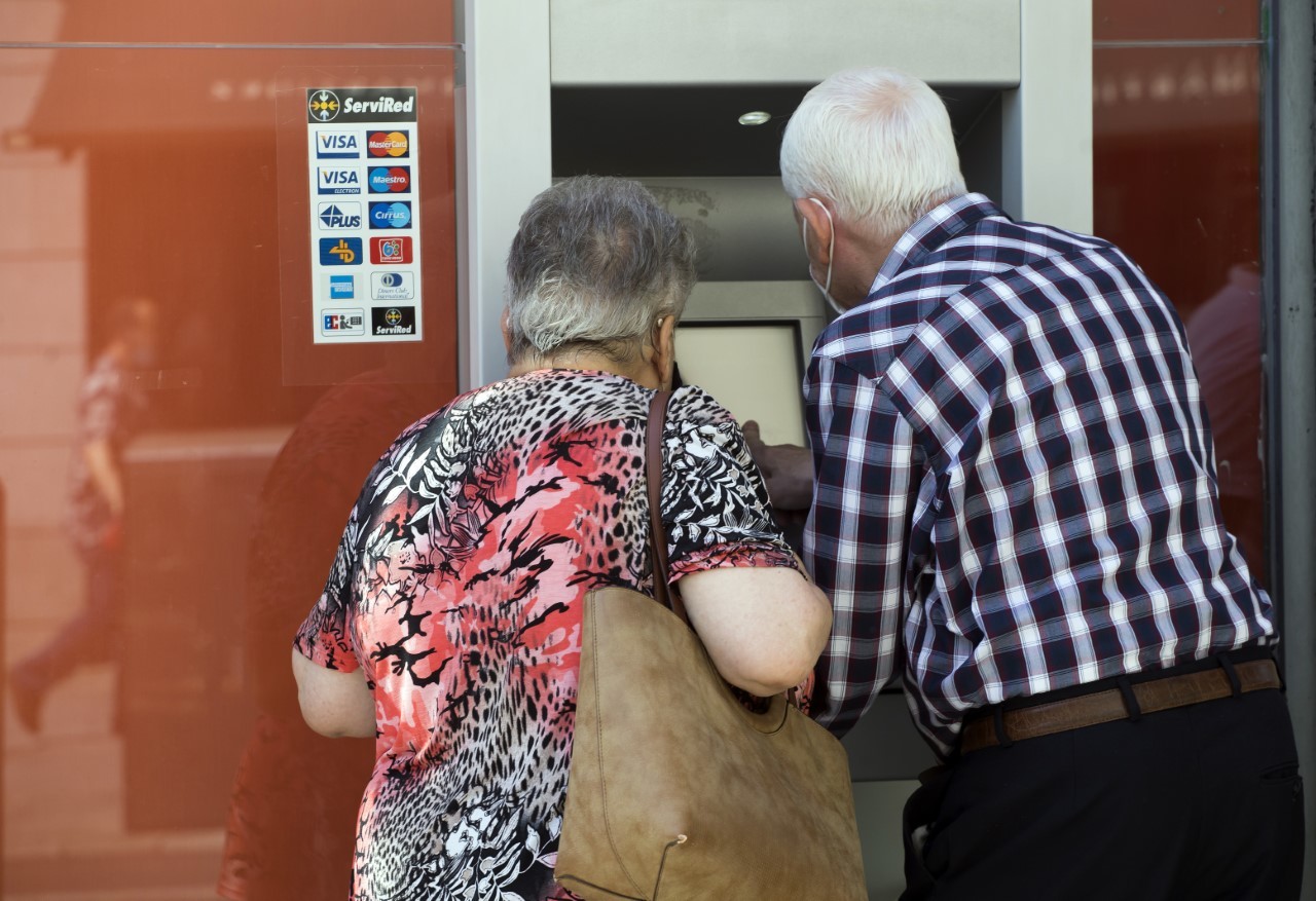 Dos clientes de un banco, en el cajero.